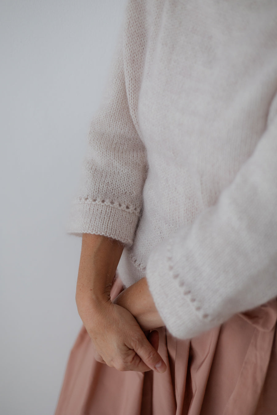 London – dettaglio manica tre quarti con bordo traforato, maglione mohair panna e gonna rosa